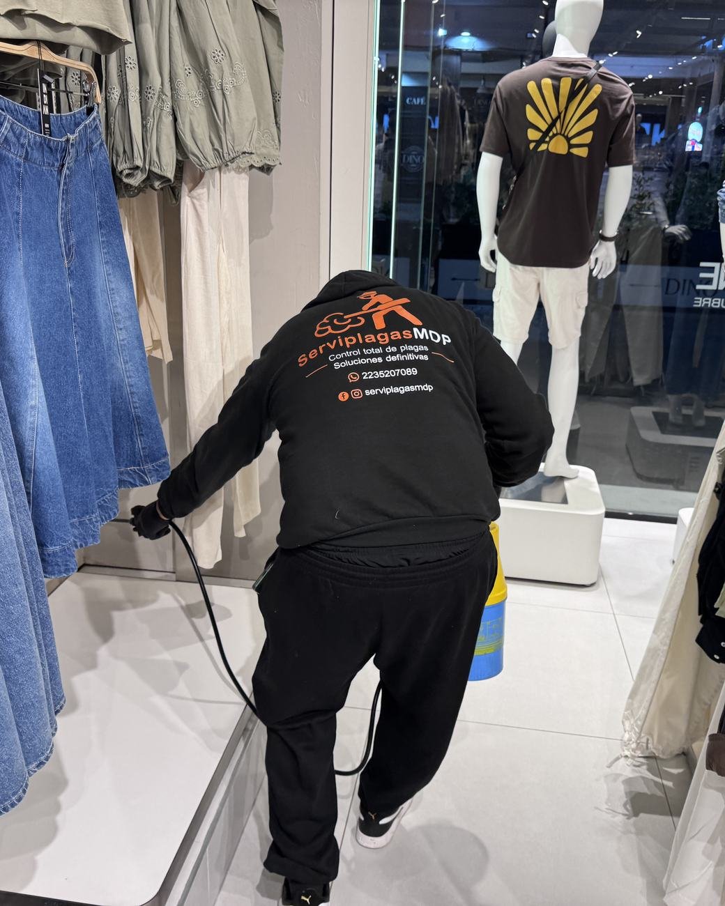 Técnico de ServiplagasMDP aplicando producto en un local de indumentaria